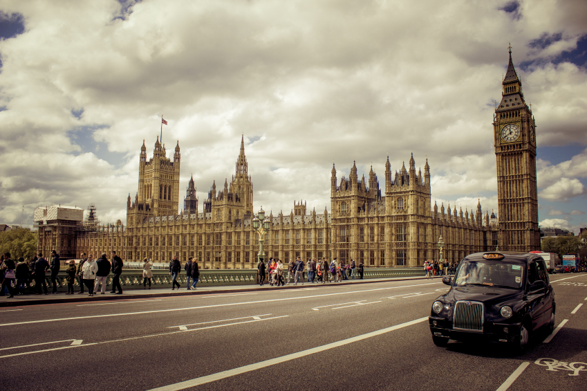 Black Cab Driving Past Houses of Parliament, London
