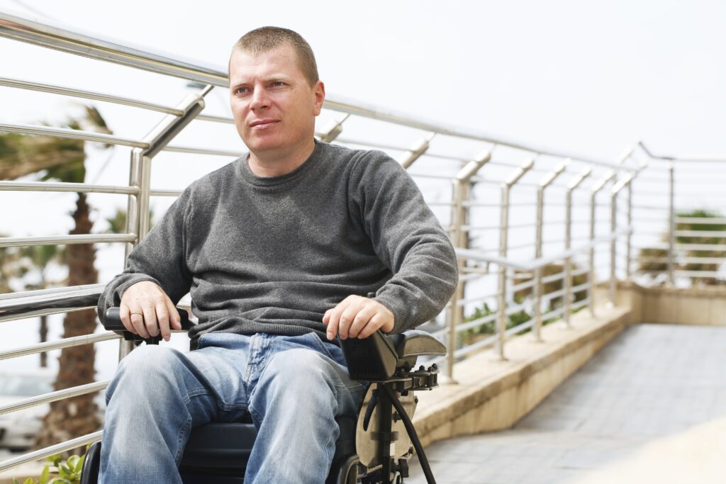 Man in wheelchair sits near the railing