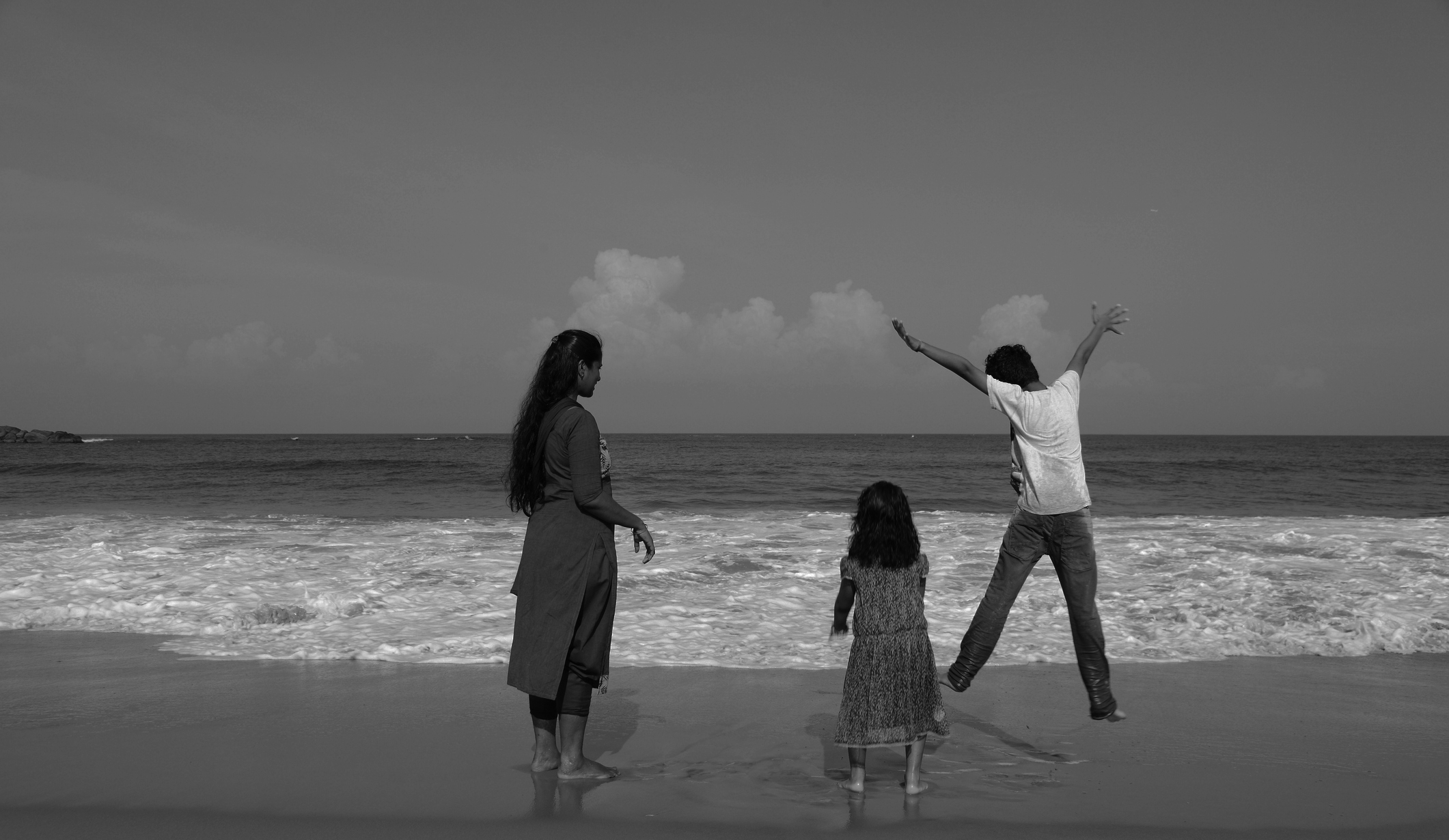 Black and White Photo of a Mother and Children on the Beach